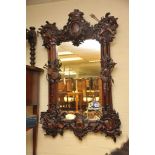 A large carved wood wall mirror of continental design,