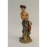 A Capodimonte figure of a young boy dressed in rags.