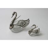 A large swan shaped facet cut  glass and silver salt with a smaller example