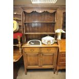 An oak dresser fitted two drawers over two cupboard doors.