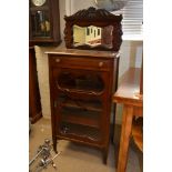 A mahogany Edwardian mirrored back music cabinet