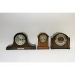 A collection of three oak mantel clocks