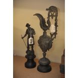 A spelter ewer and a spelter figure of a metalworker.