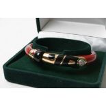 'Withdrawn - A Chinese style Nouvelle Bague bangle in red and black inset with gold