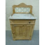 A marble-topped wash stand with tiled ba