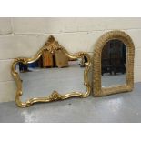 A wicker frame mirror and an ornate mirr