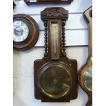 An oak carved aneroid barometer with the