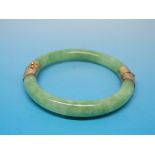 A jade or jadeite bangle with hinged yel