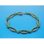 A yellow metal bracelet set with eight t