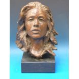 A bronze bust of a young girl signed VR