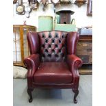 A red leather Chesterfield wing back arm