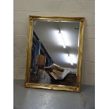 A large gilded mirror with bevelled glas