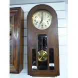 An arched top oak cased wall clock with