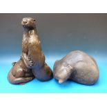 A resin model of two otters together wit