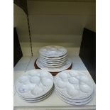 Twelve relief moulded oyster plates and another on a hardwood stand