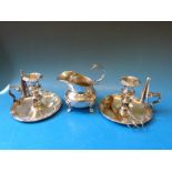 A pair of silver plated chamber sticks both with wick trimmers and snuffers together with a silver