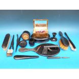 A collection of ebony dressing table items including an ebony clock etc