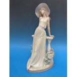 Two Lladro figures comprising a lady wearing a hat and leaning on a balustrade and a dancer