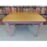 A pine kitchen table with pink painted legs (L122 x W85 x H77cm)