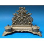 An ornate brass desk tidy with lined hinged inkwells raised on ornate scrolling feet
