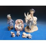 A Nao figure of a girl nursing a doll together with a Spanish model of a boy with donkey and other