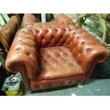 A pair of red leather Chesterfield armchairs