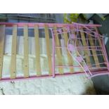 A pink bed frame with slats