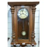 A Vienna regulator style walnut cased wall clock with ivory coloured dial and matching pendulum bob