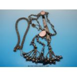 A 19thC Russian chatelaine with faceted round cut steel beads and inset pink stones,