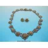 An 19thC cut steel necklace formed of raised floral links together with matching earrings