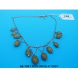 A yellow metal necklace decorated with oval jade beads