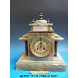 A mantel clock in green case with Roman style pillars,