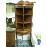 A mahogany corner cupboard together with a white swivel chair and two mirrors.
