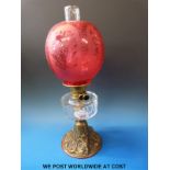 A late 19th/20thC oil lamp with acid etched globe-shaped shade,