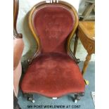 A Victorian mahogany spoon back nursing chair raised on carved cabriole supports