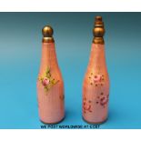 A near pair of guilloché enamel bottle shaped scent bottles with decoration of roses, tallest 6.