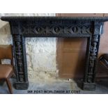 A carved and ebonised oak fire surround and overmantel with extensive figural and geometric carving,