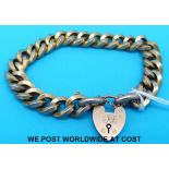 A yellow metal link bracelet marked 9ct gold with 9ct gold heart padlock clasp (18g)