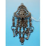 A 19thC Russian white metal cut steel chatelaine with two keys to the end