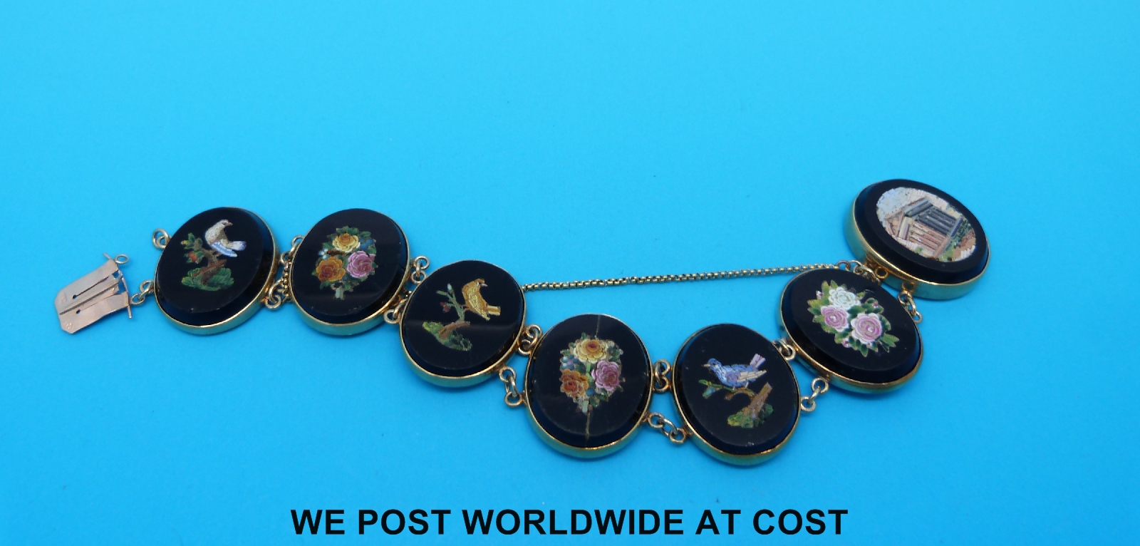 A yellow metal and micro-mosaic bracelet marked 9ct comprising seven oval panels decorated with