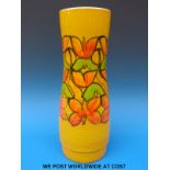 A large retro Poole pottery vase with decoration of flowers on a yellow ground,