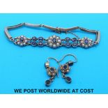 A yellow metal bracelet set with sapphires and seed pearls in floral clusters together with