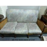 A mahogany bergere and upholstered sofa raised on eight ball and claw feet
