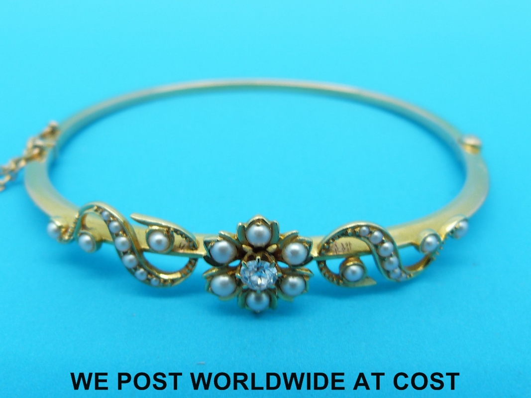 An Edwardian gold bangle set with a diamond and seed pearls in a floral design, - Image 3 of 3