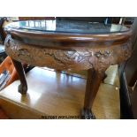A Chinese carved dark elm glass topped round coffee table with four quarter smaller tables under.