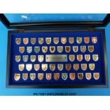 A display box containing 50 coats of arms of great monarchs of history from the Heraldry Society of