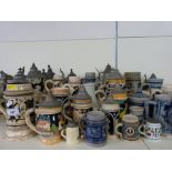 A large collection of various sized Bavarian steins including some small/miniature examples,