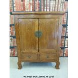 A Chinese elm two door cabinet with drawers under, raised on shaped front legs,