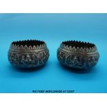 A pair of Indian white metal bowls with embossed decoration of goddesses (8cm diameter)