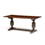 A late Victorian oak trestle table the rectangular top on leaf-carved baluster supports and shaped